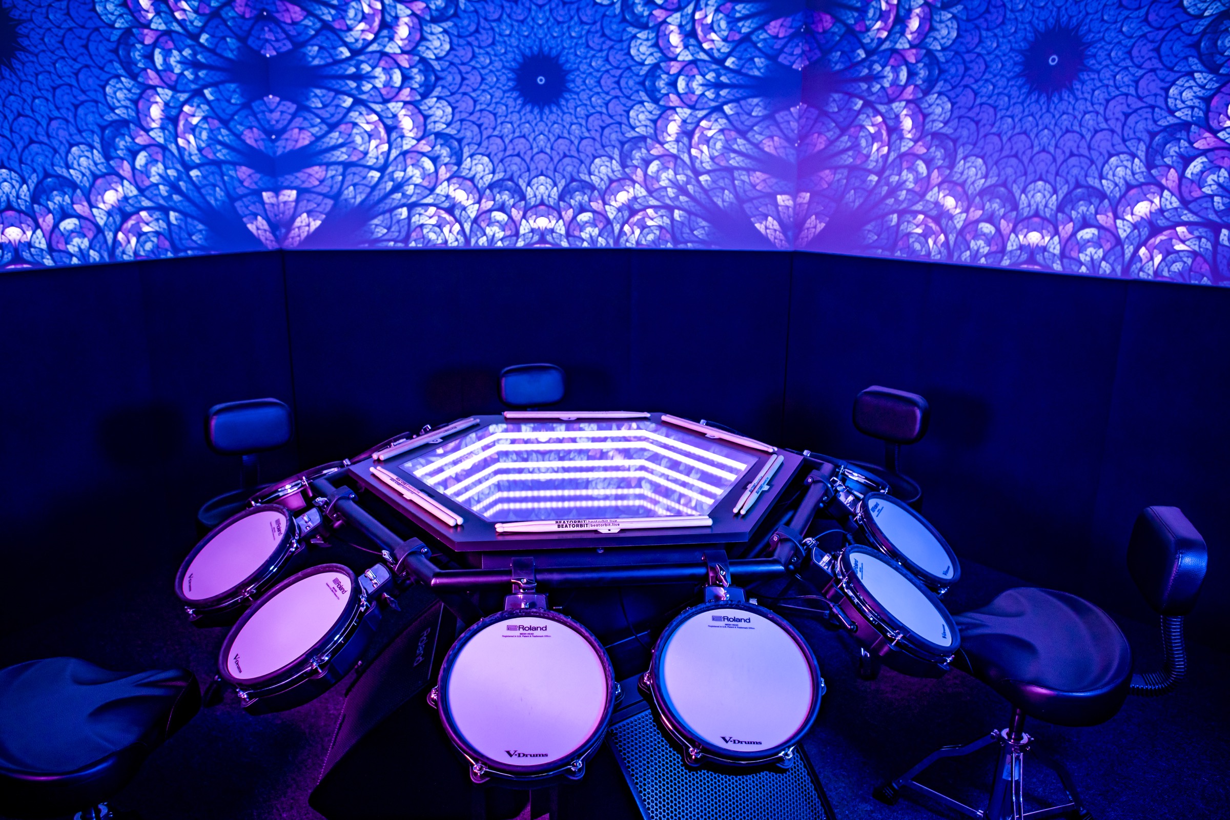 The illuminated BeatOrbit table surrounded by drum pads