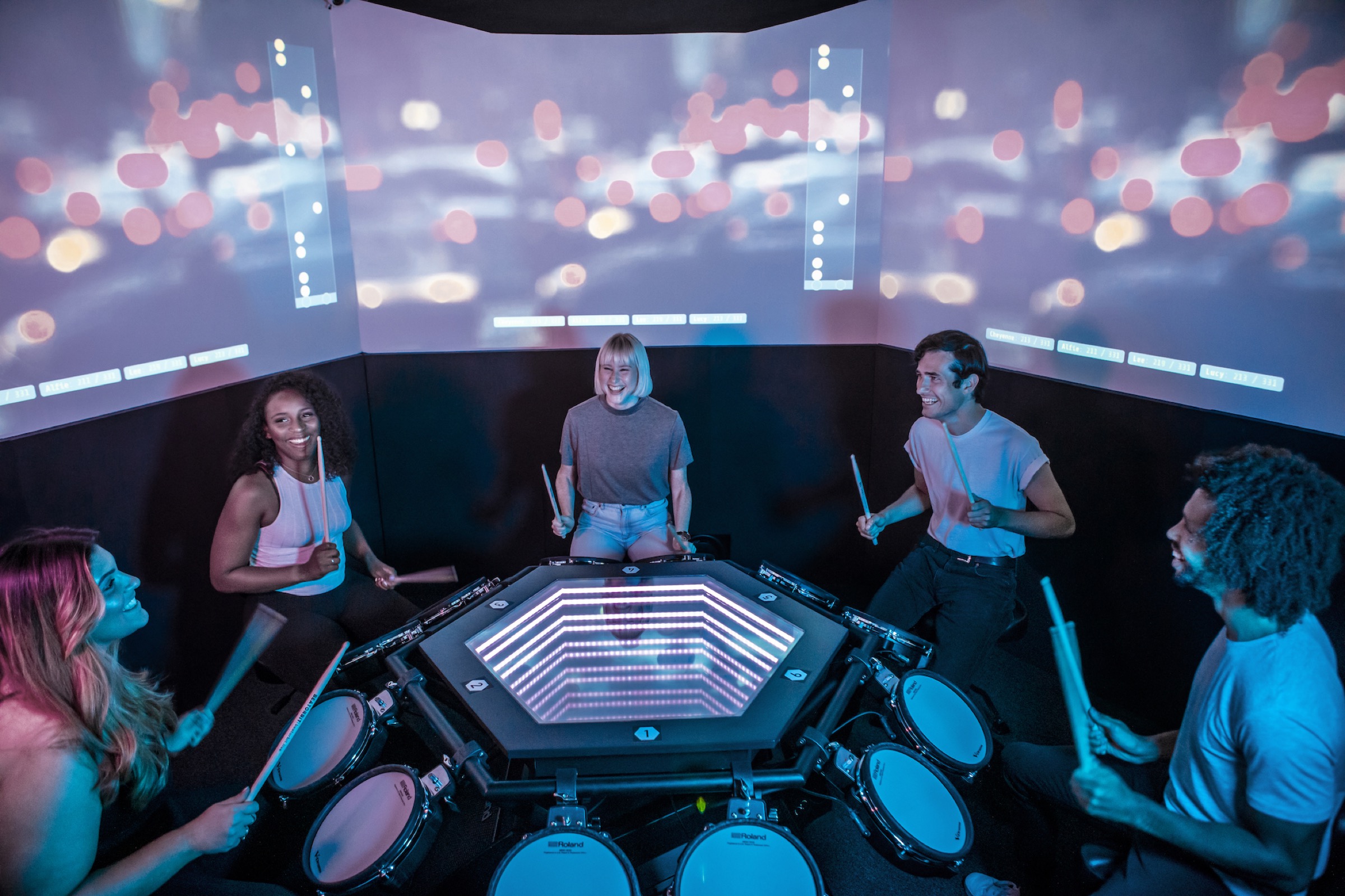 Friends drumming together around the illuminated table