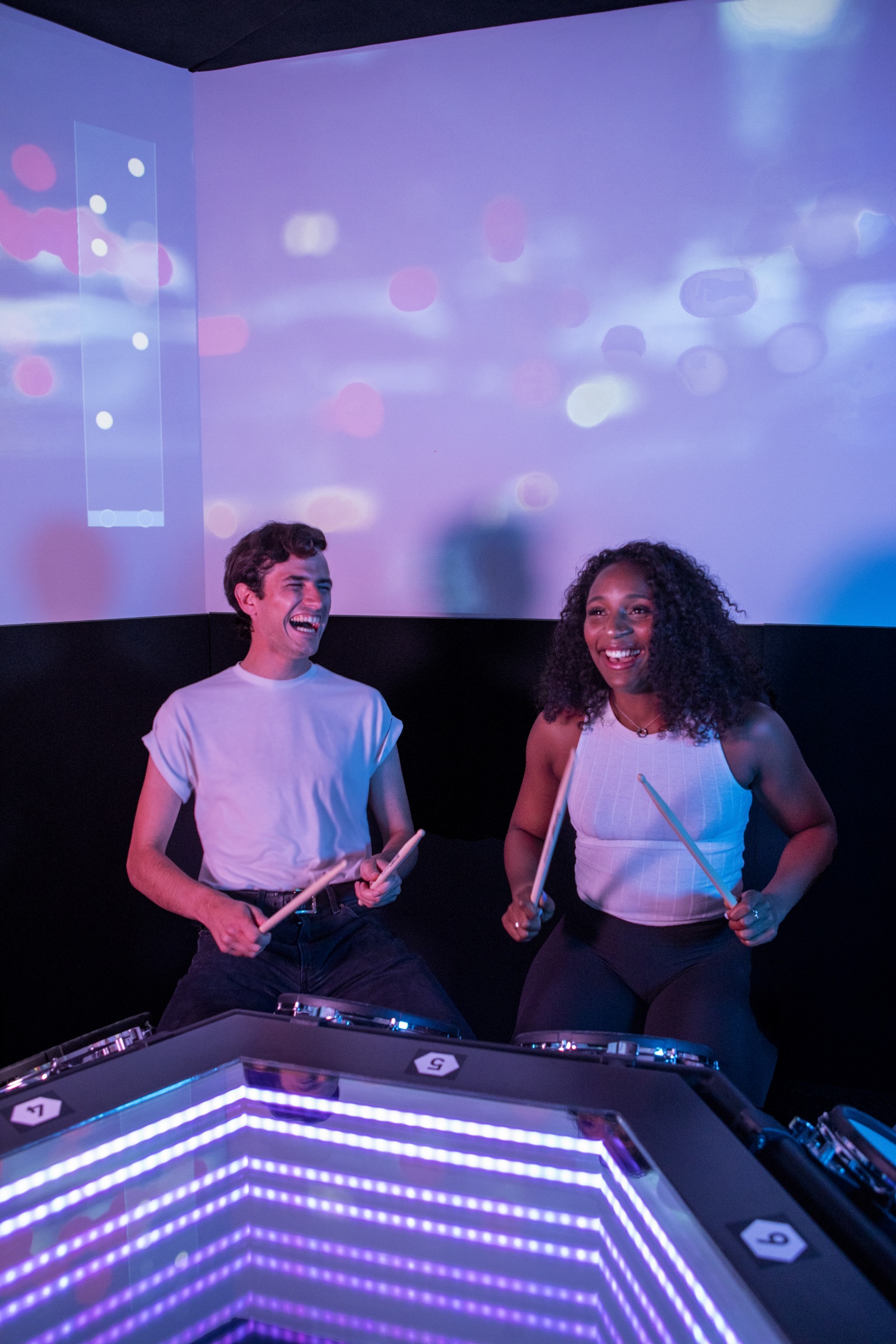 Two BeatOrbit guests smiling under projected light