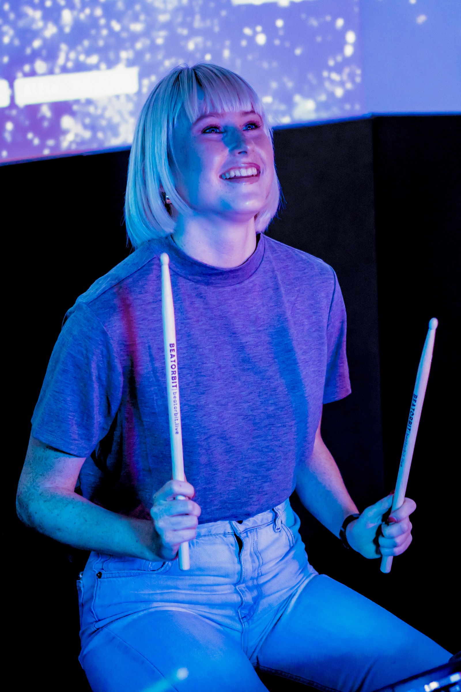 A BeatOrbit guest smiling with drumsticks